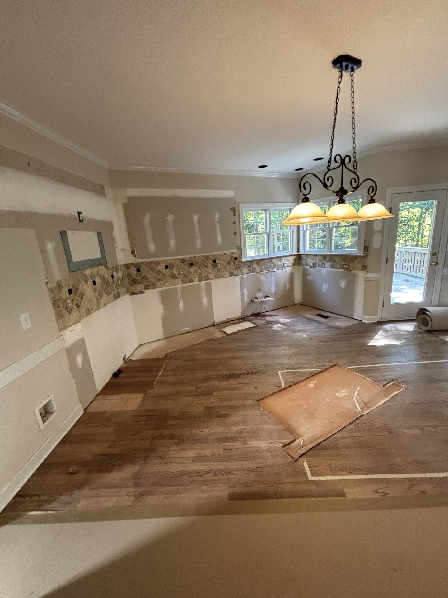 The same kitchen with cabinets, counters, island, and appliances removed down to bare walls