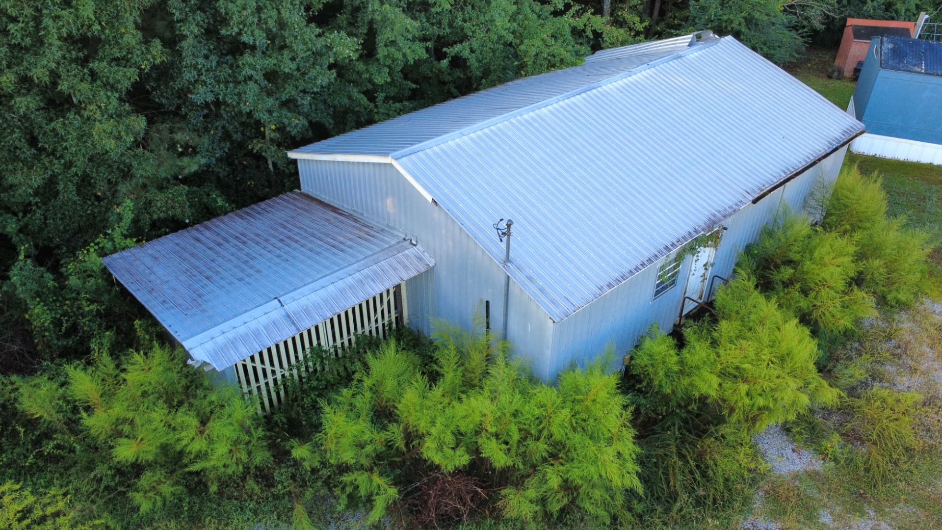 Aerial view of a metal outbuilding with a carport before demolition