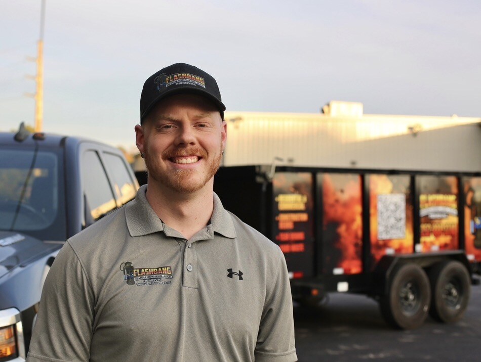Chris Jones, owner of Flashbang Dumpsters and Demolition, in front of his branded truck and trailer